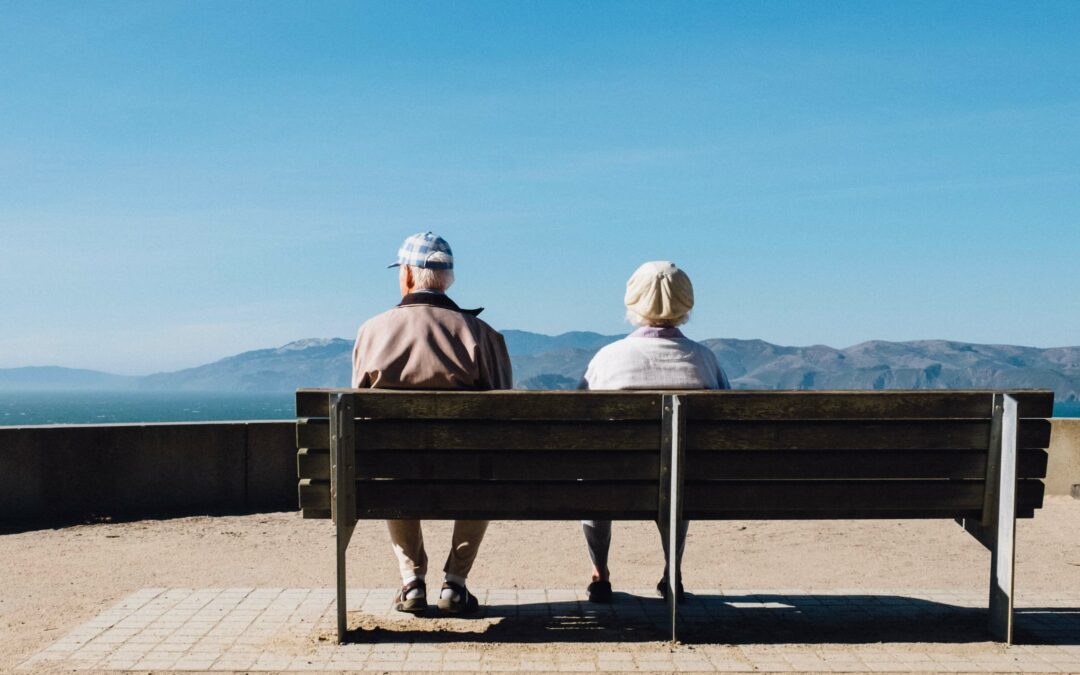 Elderly couple admiring a view, discussing questions about Medicare and who pays first.