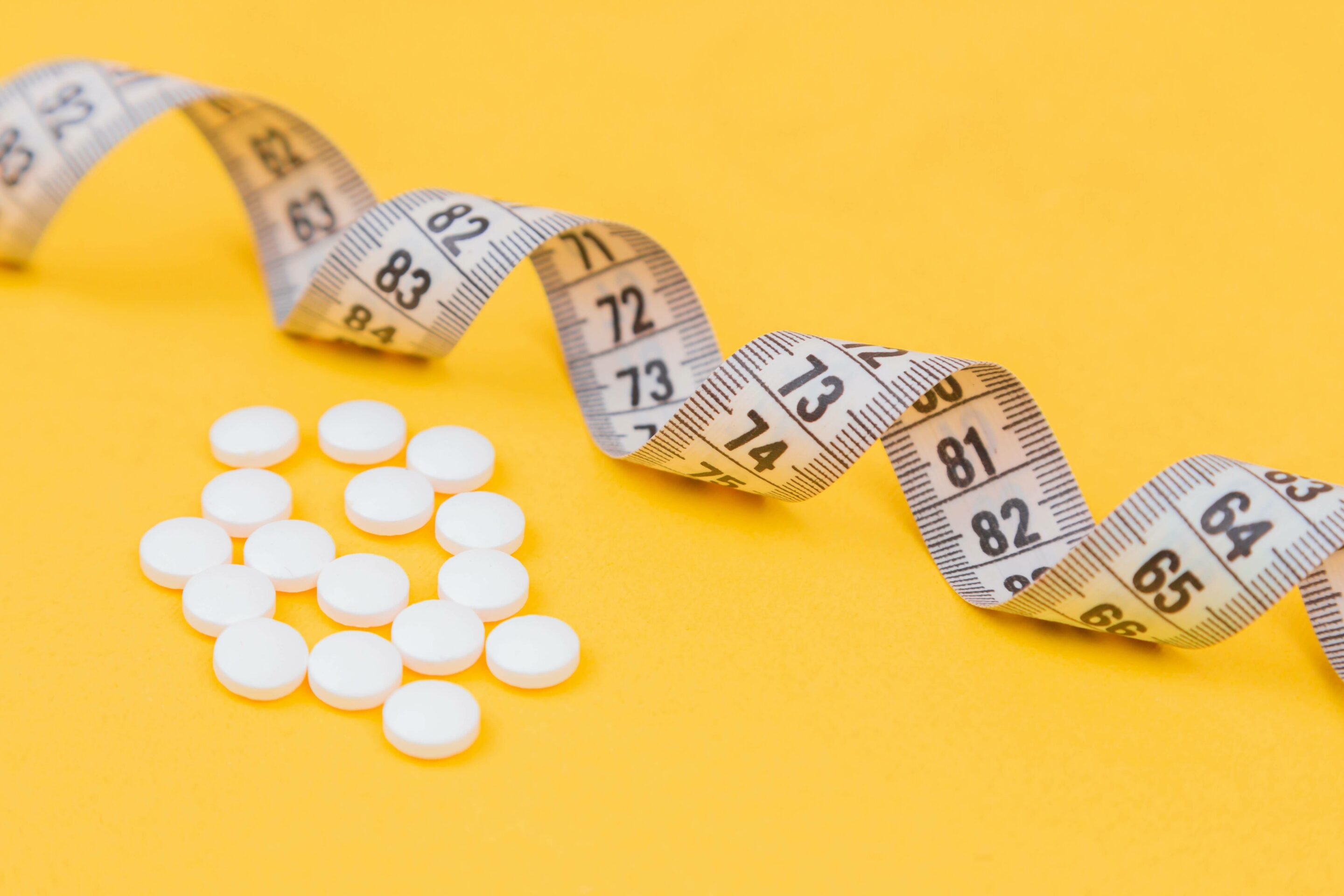 a measurement tape and weight loss drugs
